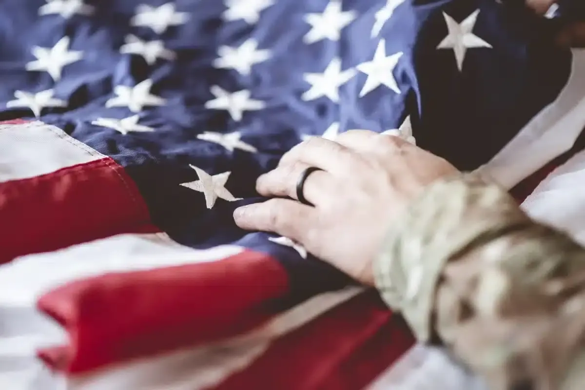 Mano apoyada sobre una bandera de Estados Unidos
