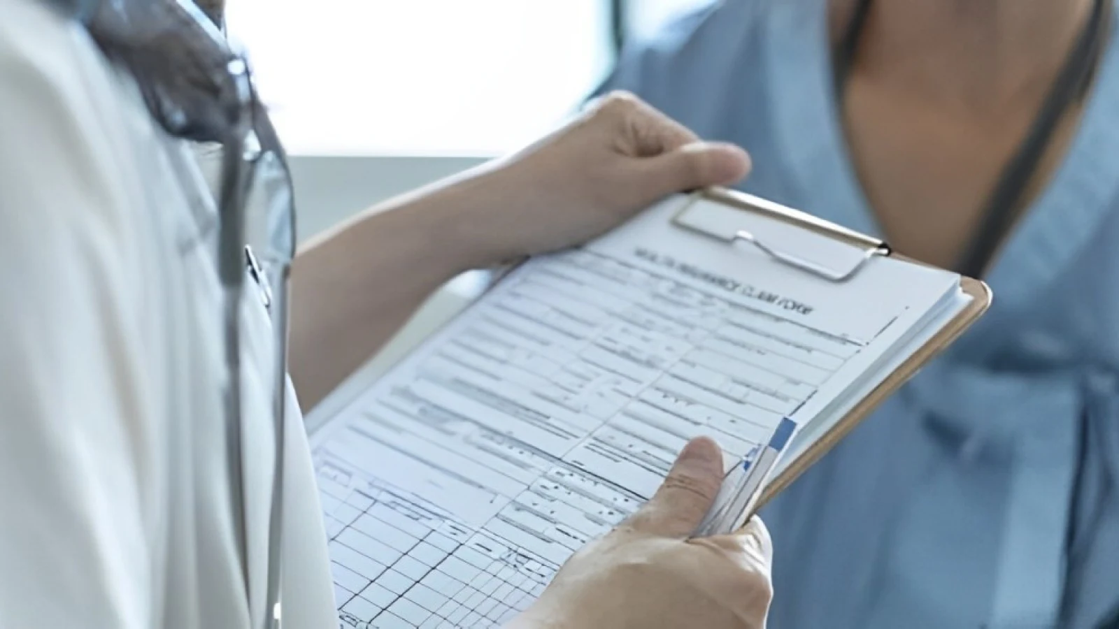 Medical professional discussing a health insurance claim form with a patient