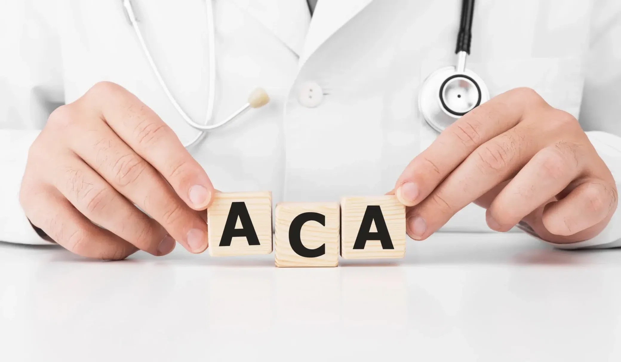 Médico acomodando bloques de madera que forman las letras ACA