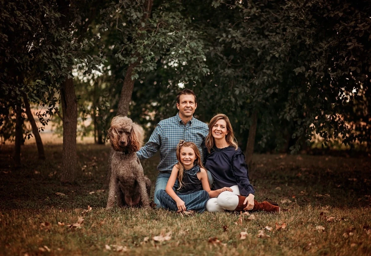 Familia sentada al aire libre con su perro