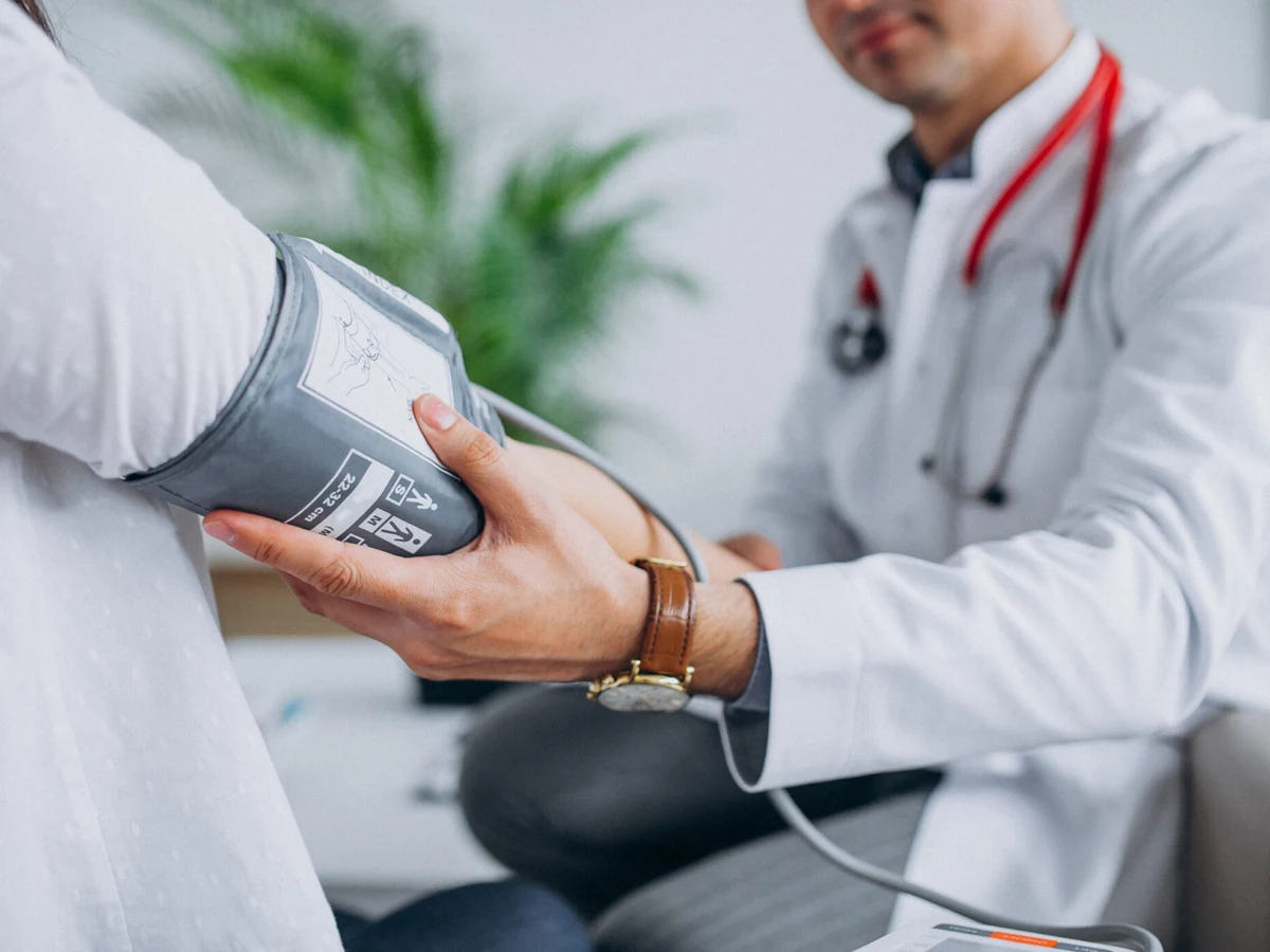 Médico tomando la presión arterial de un paciente mayor