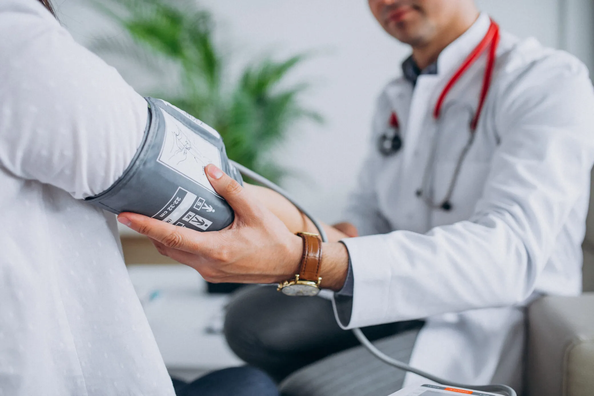 Médico que toma la presión arterial de un paciente mayor.